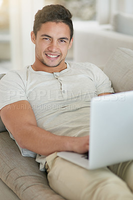 Buy stock photo Laptop, sofa and portrait of man doing remote work in his home, house or apartment with smile and relax. Couch, happy and young male person or student typing a project online, website or web