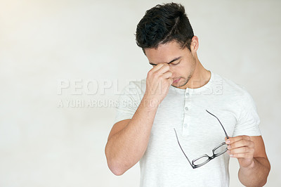 Buy stock photo Studio shot of a young man looking stressed against a light background