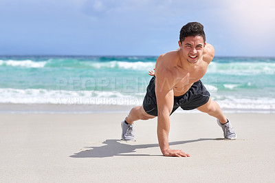 Buy stock photo Portrait of a handsome young man doing one handed pushups on the beach