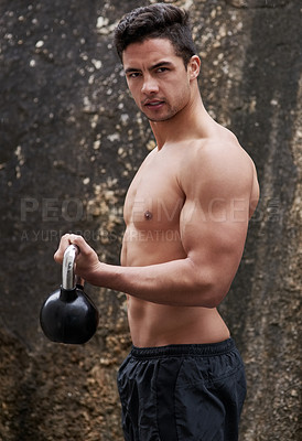 Buy stock photo Portrait of a handsome young man working out with a kettle bell outside