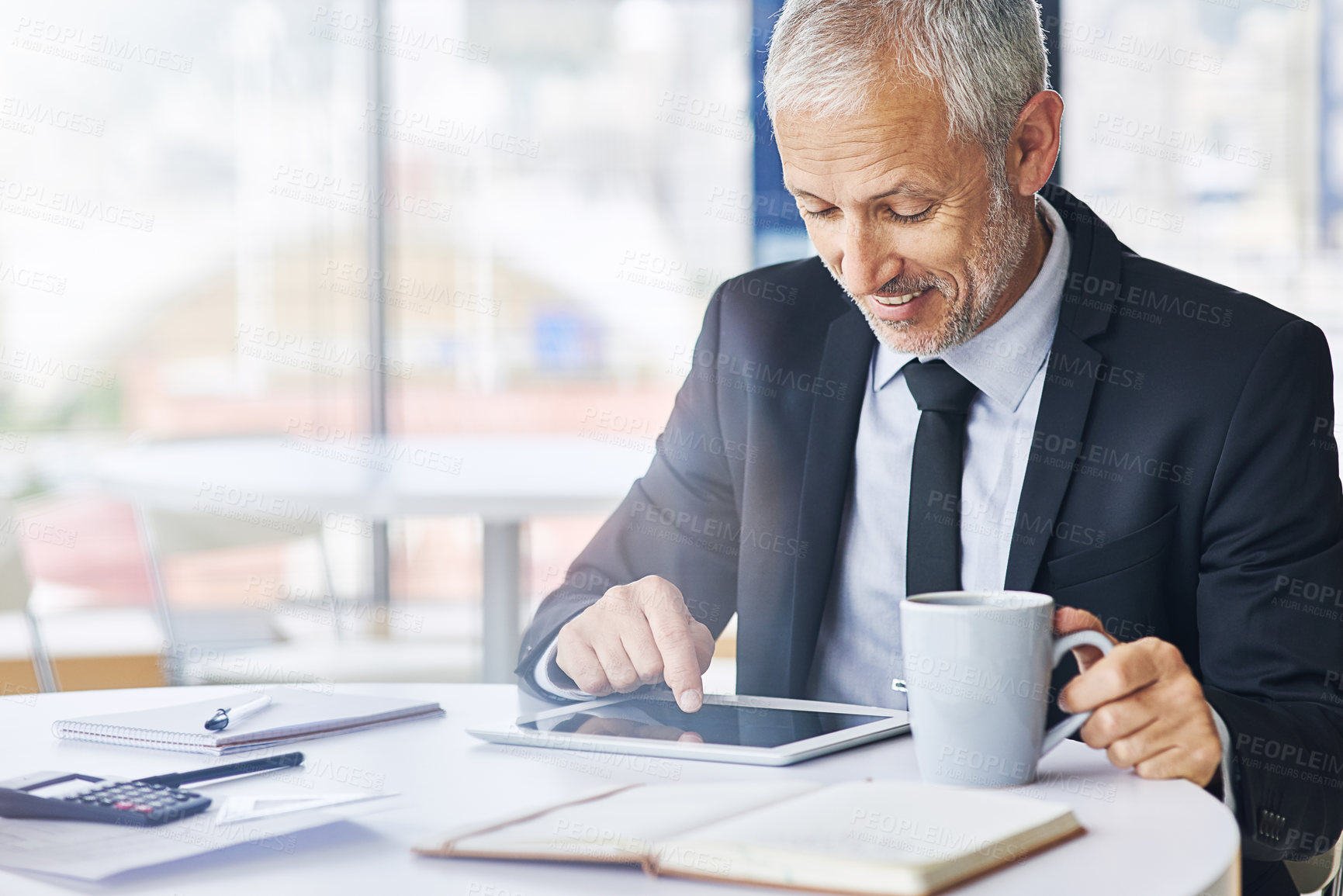 Buy stock photo Cropped shot of a mature businessman working on a digital tablet in an office