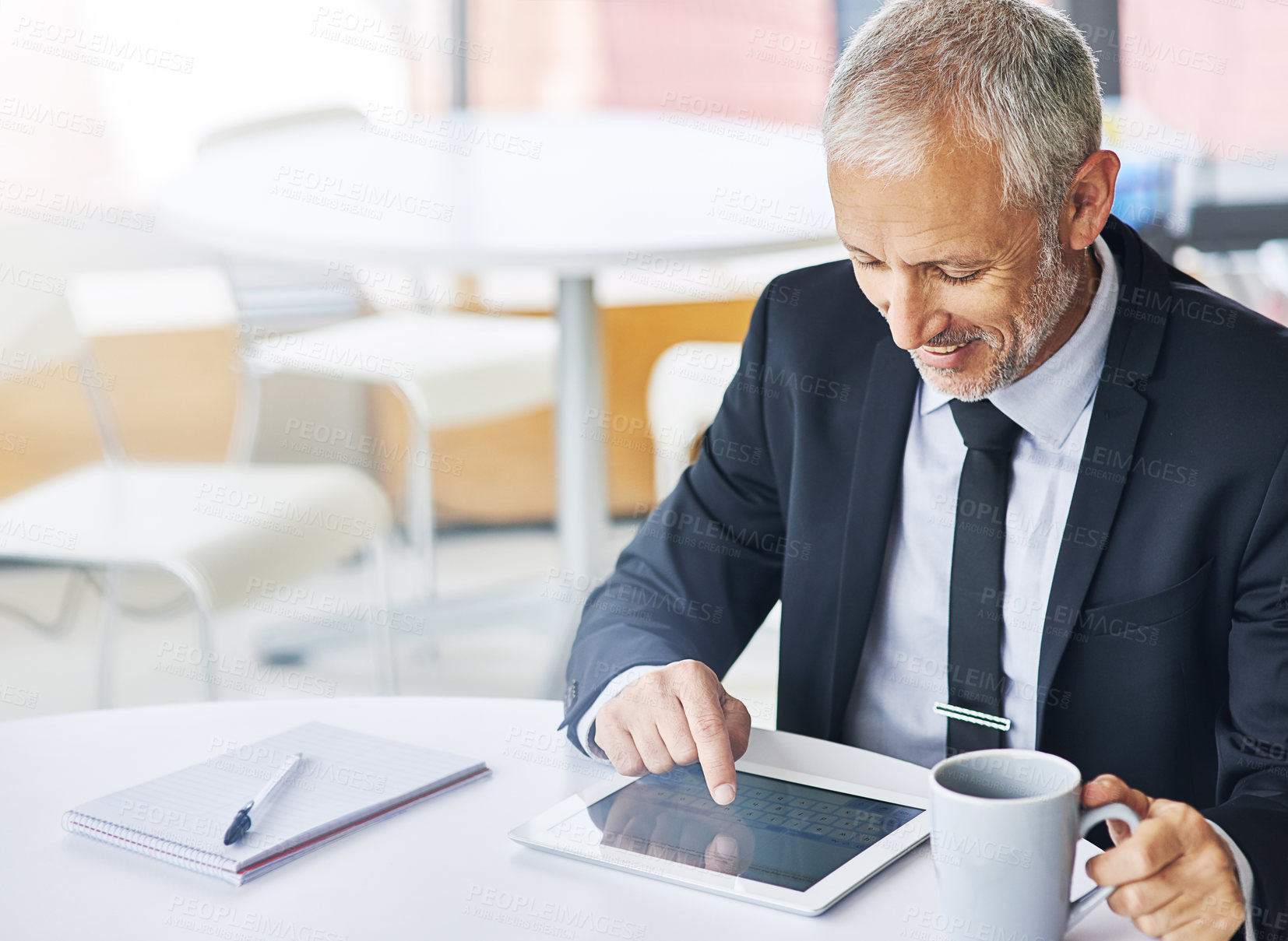 Buy stock photo Cropped shot of a mature businessman working on a digital tablet in an office