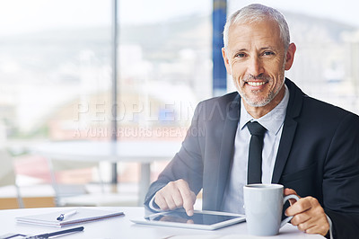 Buy stock photo Portrait of a mature businessman working on a digital tablet in an office