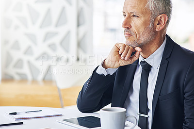 Buy stock photo Cropped shot of a mature businessman looking thoughtful while working in an office