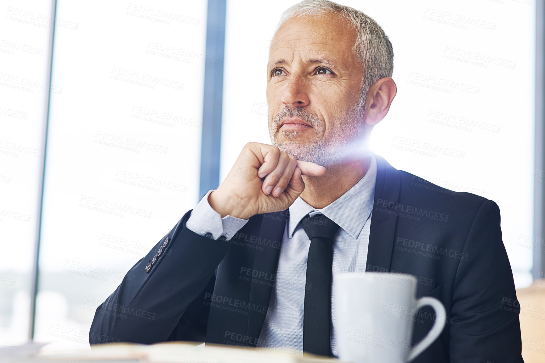 Buy stock photo Cropped shot of a mature businessman looking thoughtful while working in an office