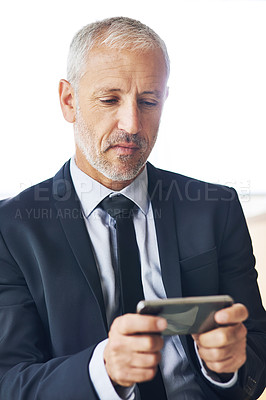 Buy stock photo Cropped shot of a mature businessman texting on a cellphone in an office