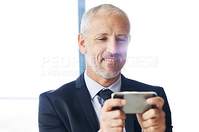 Buy stock photo Cropped shot of a mature businessman texting on a cellphone in an office