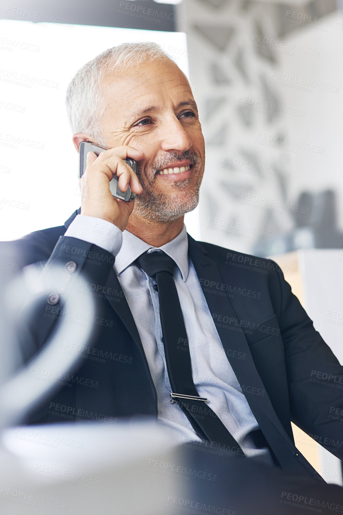 Buy stock photo Cropped shot of a mature businessman talking on a cellphone in an office