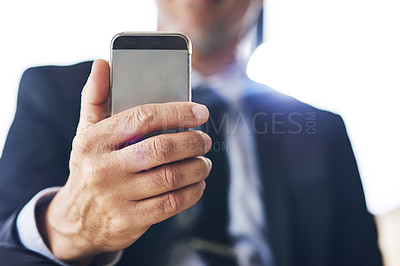 Buy stock photo Closeup shot of a corporate businessman using a cellphone in an office