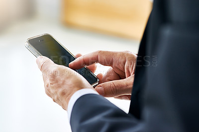 Buy stock photo Closeup shot of a corporate businessman texting on a cellphone in an office