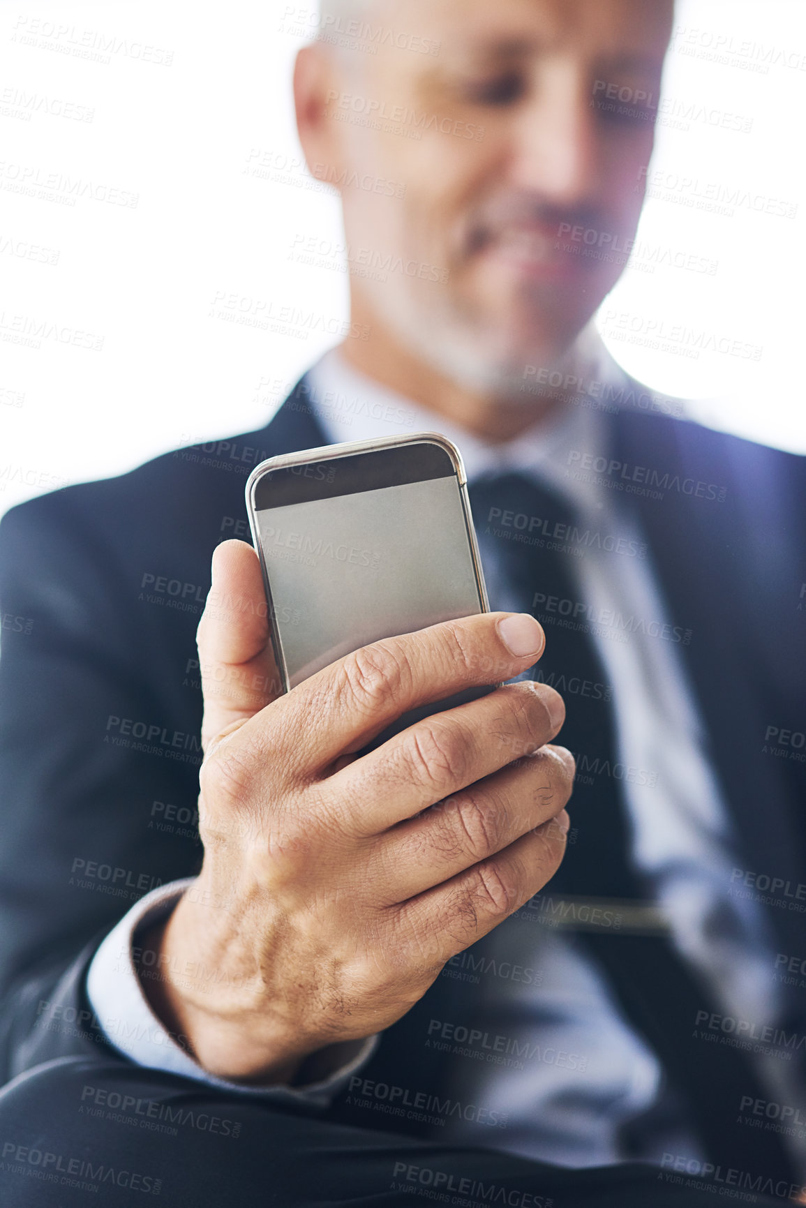 Buy stock photo Closeup shot of a corporate businessman using a cellphone in an office