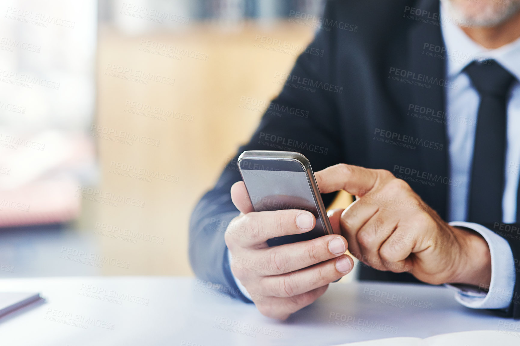 Buy stock photo Closeup shot of a corporate businessman texting on a cellphone in an office