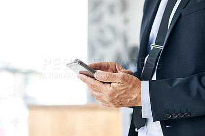 Buy stock photo Closeup shot of a corporate businessman texting on a cellphone in an office