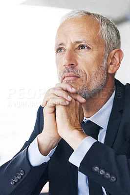 Buy stock photo Cropped shot of a mature businessman looking thoughtful while sitting in an office