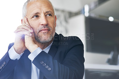 Buy stock photo Cropped shot of a mature businessman looking thoughtful while sitting in an office