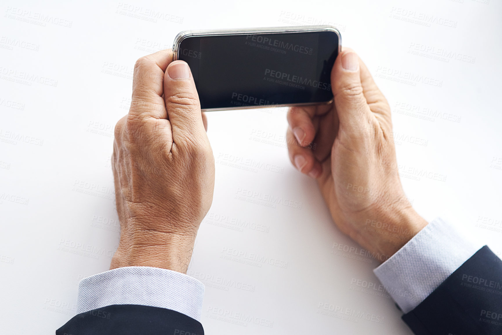 Buy stock photo Closeup shot of a businessman using a cellphone against a white background