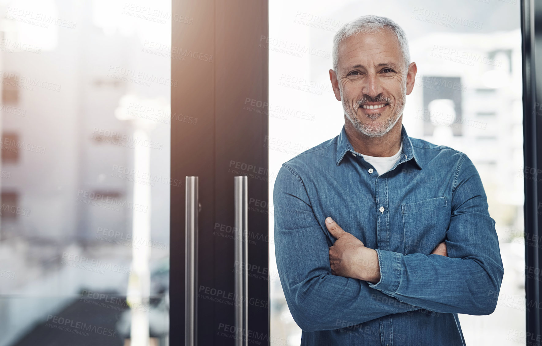 Buy stock photo Mature, portrait and businessman with confidence by window at office for job or career startup. Male person, happy designer or creative employee with smile or arms crossed for professional expertise