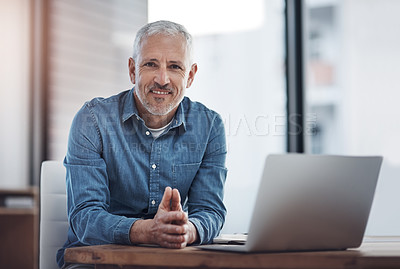 Buy stock photo Portrait of a mature businessman working on a laptop in an office
