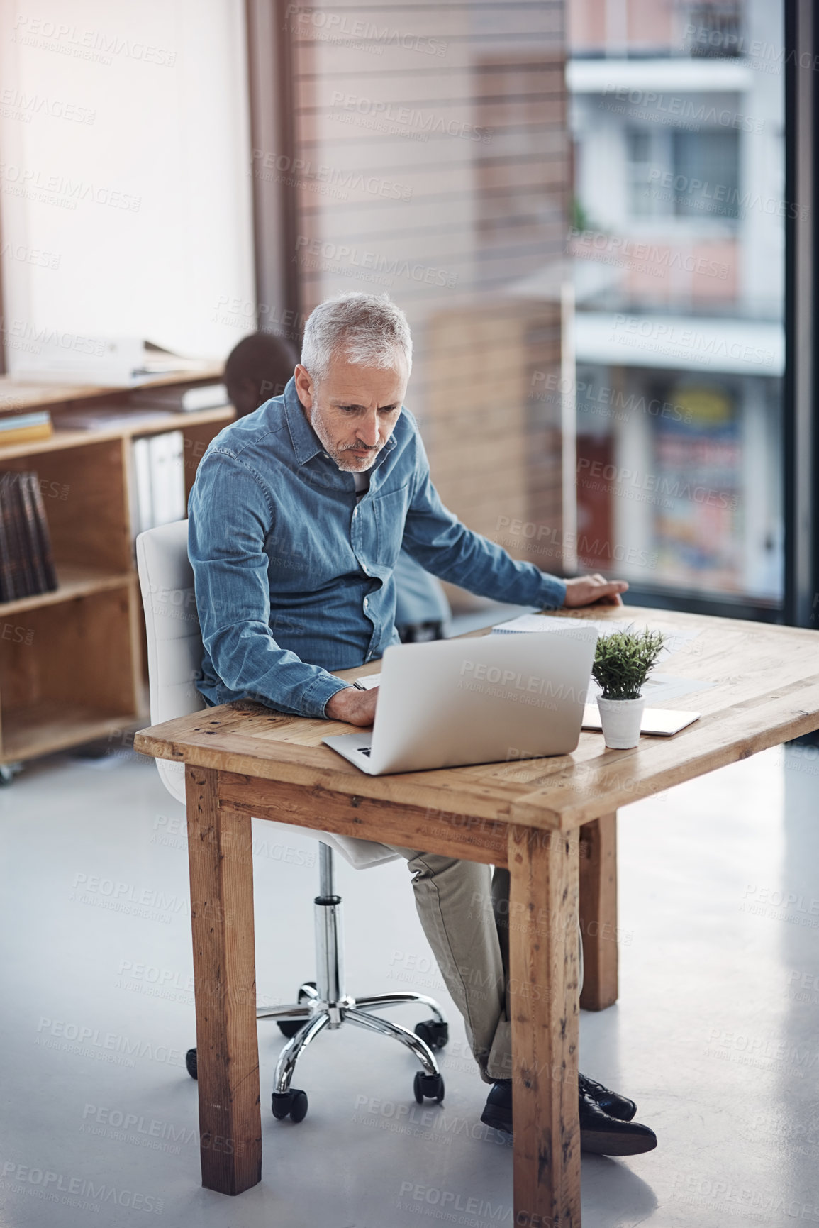 Buy stock photo Businessman, laptop and reading in office for finance, budget review and planning in accounting firm. Mature accountant, computer or research in workplace for productivity, fund allocation or banking