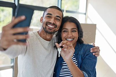 Buy stock photo Shot of a happy young couple taking a selfie while moving into their new house together