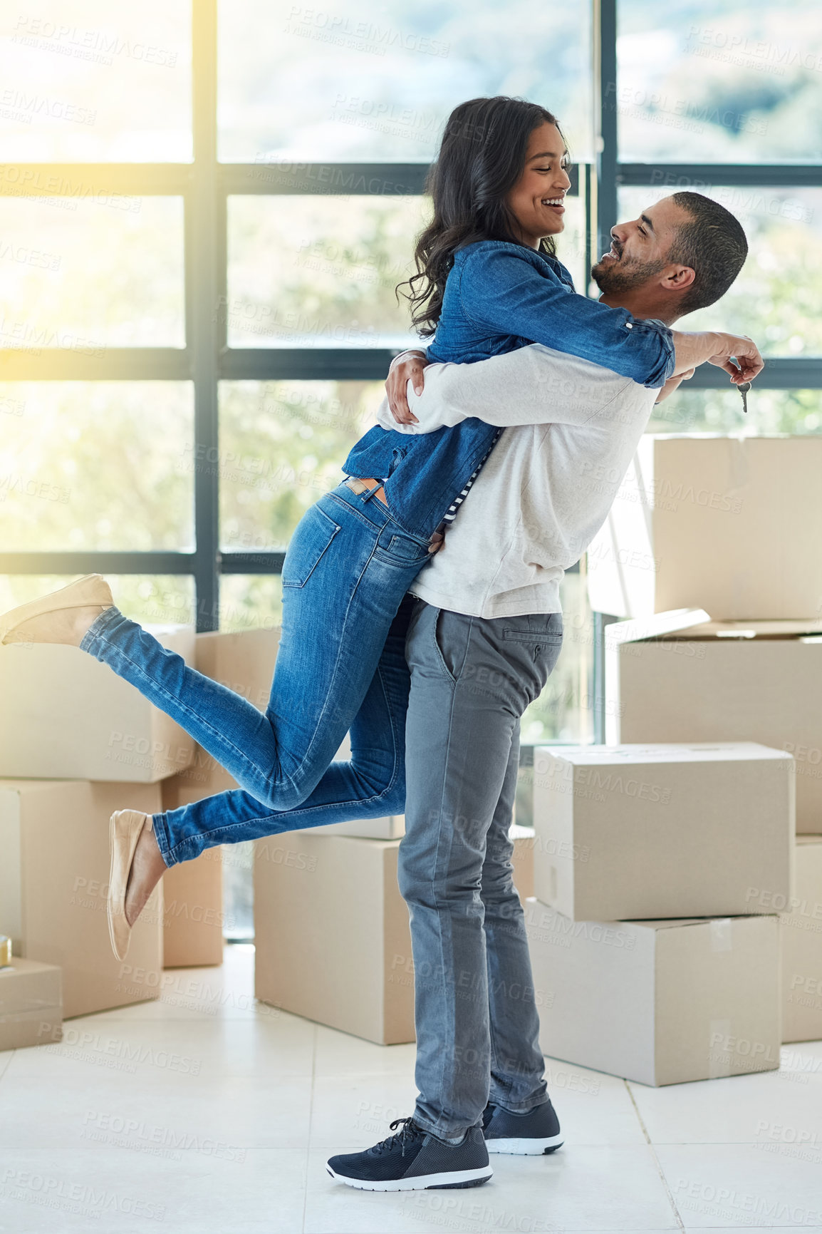 Buy stock photo Shot of a happy young couple moving into their new home together