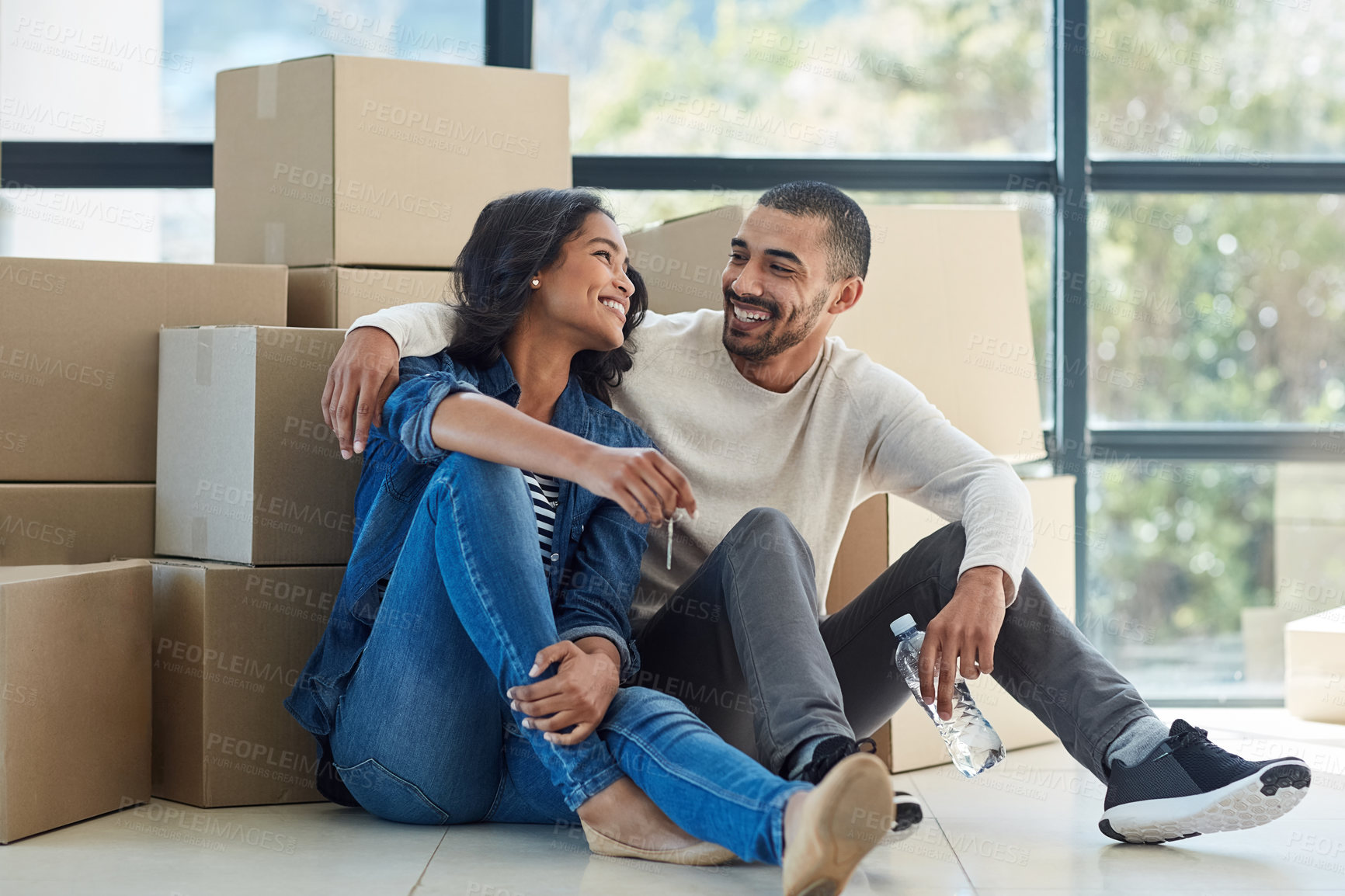 Buy stock photo Shot of a happy young couple moving into their new home together