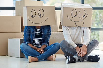 Buy stock photo Shot of a fun couple sharing a light-hearted moment while moving into their new home together