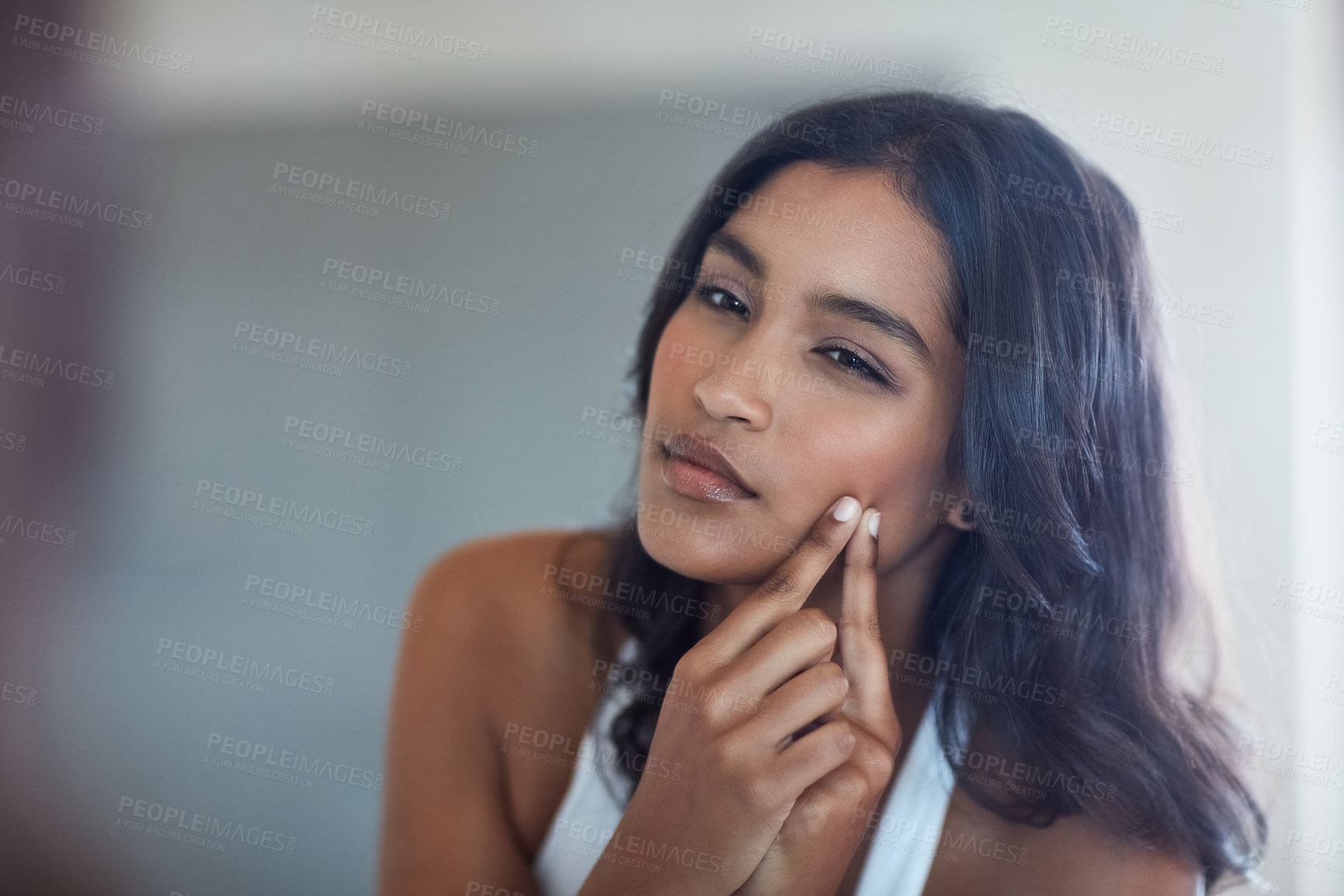 Buy stock photo Skincare, woman and face and acne with mirror reflection in bathroom for grooming and morning routine. Indian, female person and dermatology with hand for popping pimple or blackhead for breakout