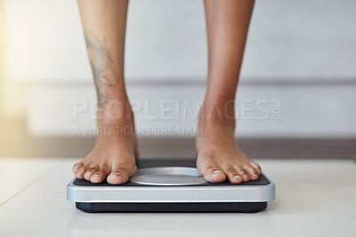 Buy stock photo Closeup shot of a woman weighing herself on a scale at home