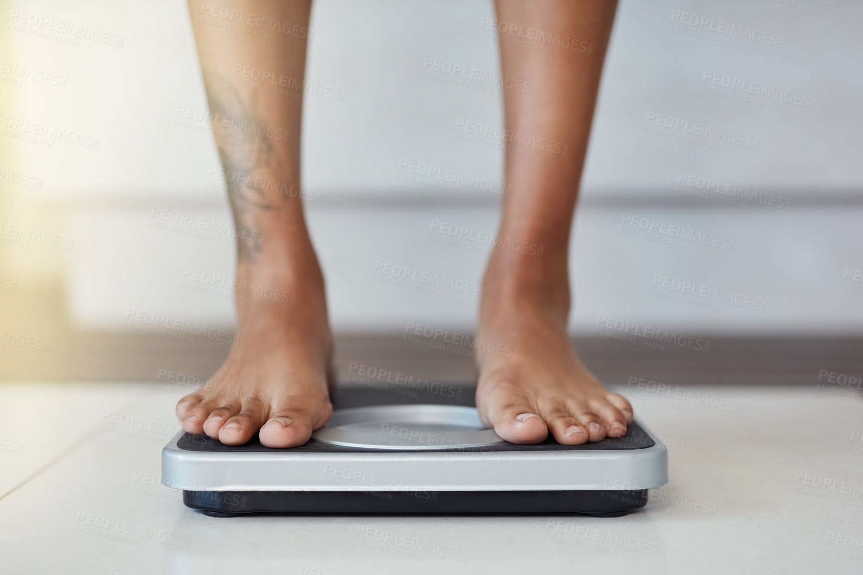 Buy stock photo Closeup shot of a woman weighing herself on a scale at home