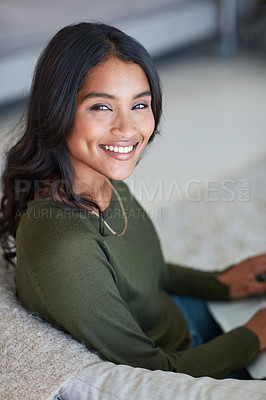 Buy stock photo Portrait of an attractive young woman sitting on the sofa at home
