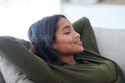 Buy stock photo Shot of an attractive young woman relaxing on her sofa at home