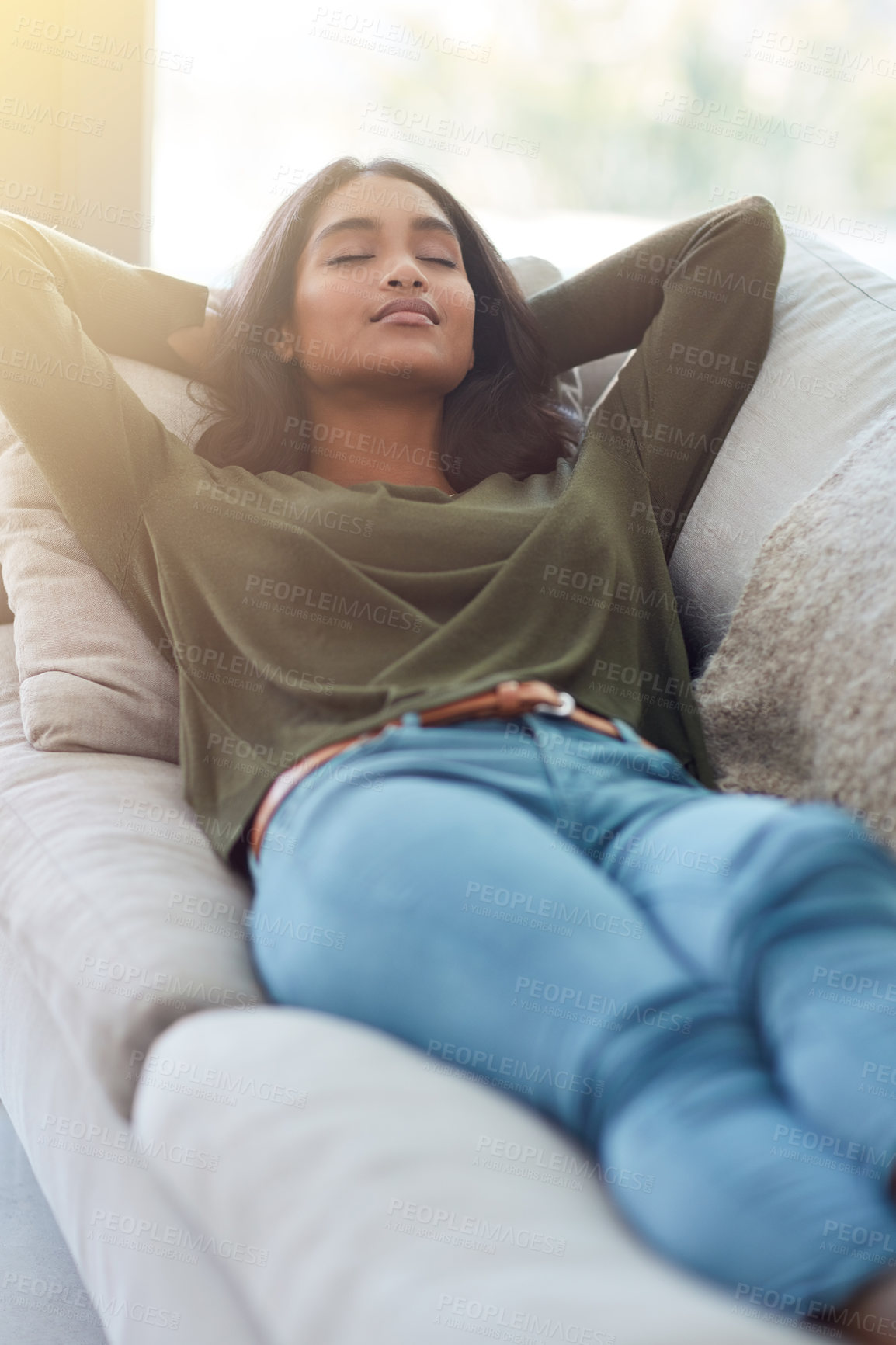 Buy stock photo Shot of an attractive young woman relaxing on her sofa at home