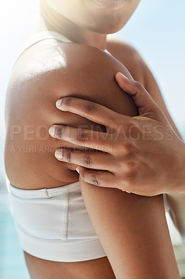 Buy stock photo Shot of a sportswoman with a shoulder injury