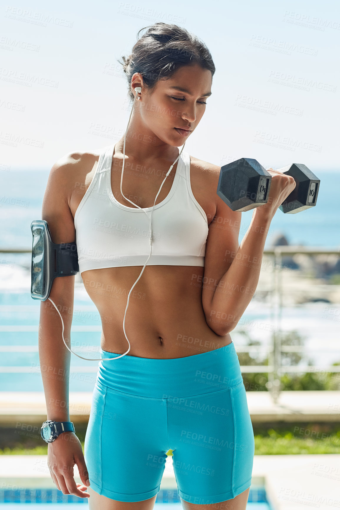 Buy stock photo Indian girl, earphones and dumbbell for workout in outdoor, bicep and training for muscle growth. Female person, confident and music for weight lifting, strong body and sound for power or health