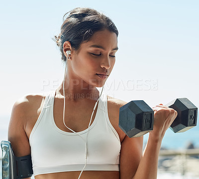 Buy stock photo Cropped shot of a young woman using dumbbells in her workout routine