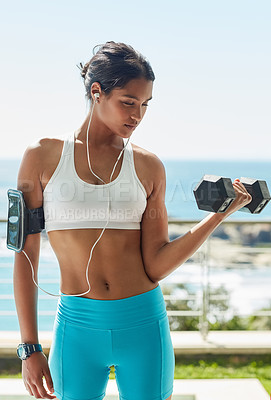 Buy stock photo Cropped shot of a young woman using dumbbells in her workout routine
