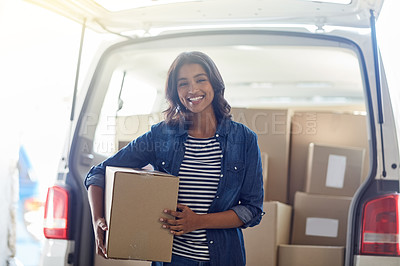 Buy stock photo Portrait of an attractive young woman unpacking boxes from the trunk of her car
