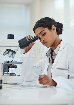 Buy stock photo Cropped shot of a young female scientist recording her findings on a digital tablet