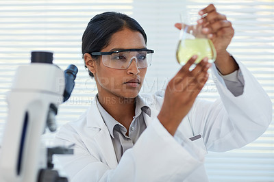 Buy stock photo Cropped shot of a young female scientist conducting an experiment in a lab