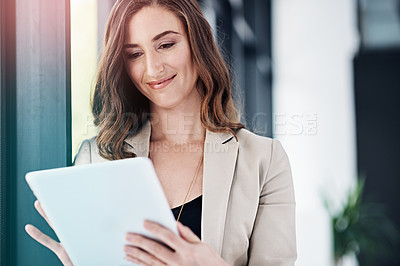 Buy stock photo Shot of a successful businesswoman using her tablet the office