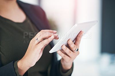 Buy stock photo Shot of an unrecognizable businesswoman using her tablet the office
