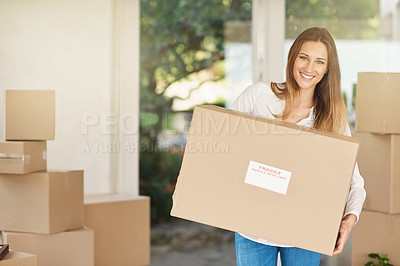 Buy stock photo Portrait of a smiling young woman carrying a box on moving into her new house