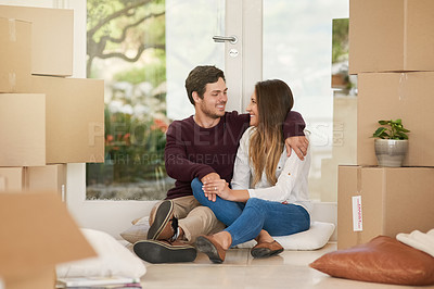 Buy stock photo Shot of an affectionate young couple taking a break while moving into a new home