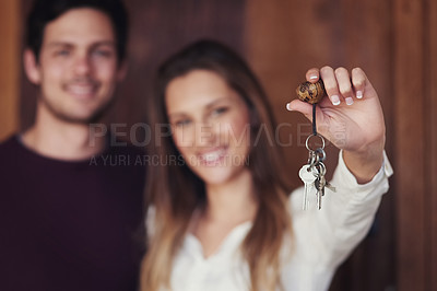 Buy stock photo Portrait of a young couple holding up the keys to their new home