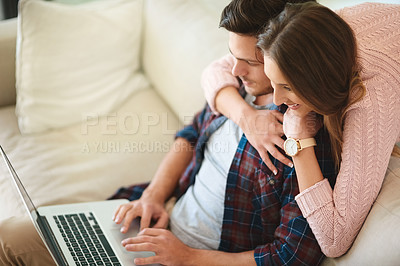 Buy stock photo Shot of a happy young couple using a laptop together while relaxing on the   sofa at home