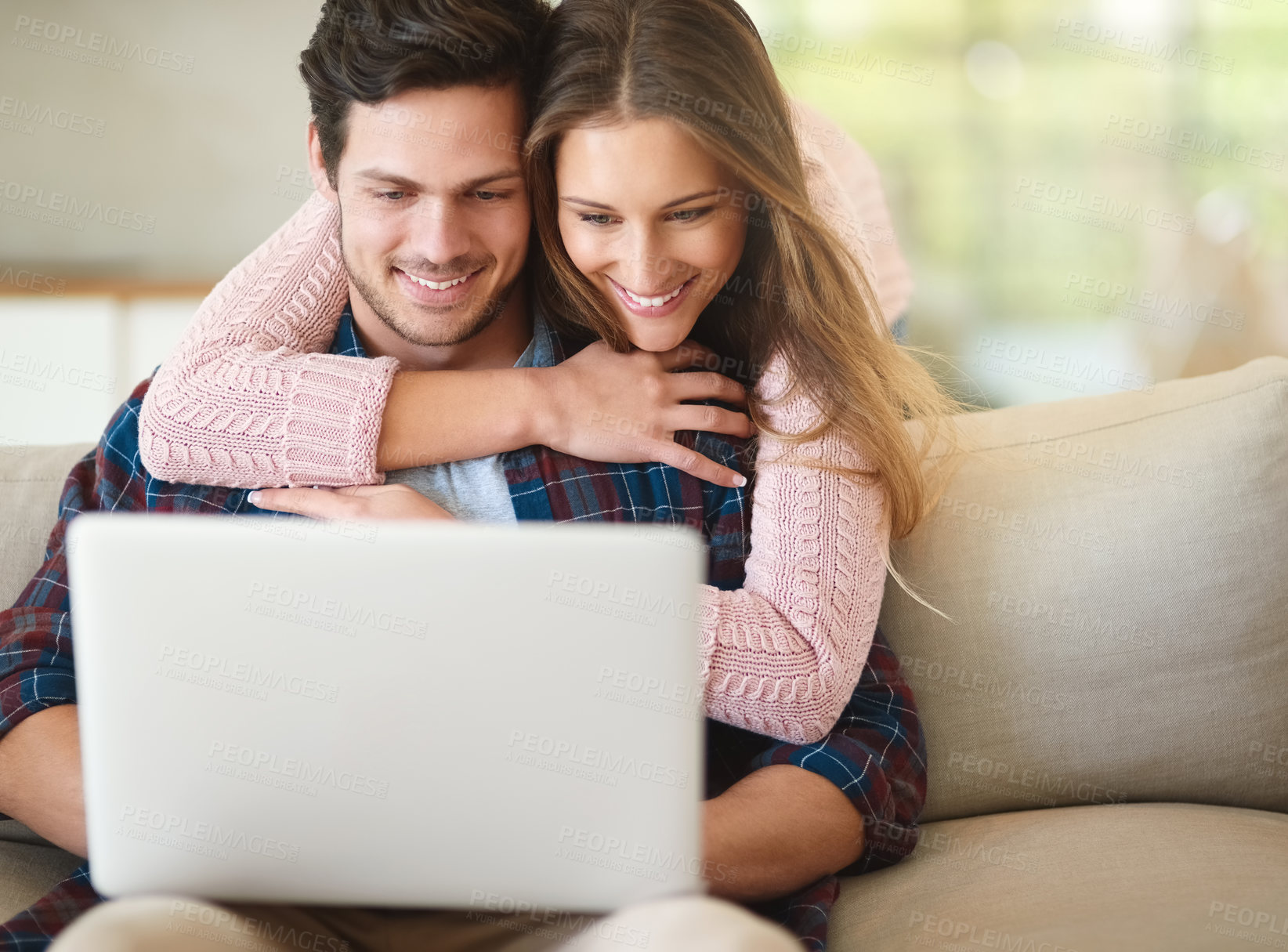 Buy stock photo Shot of a happy young couple using a laptop together while relaxing on the   sofa at home