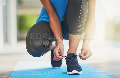 Buy stock photo Shot of an unrecognizable woman tying her shoelaces before a workout