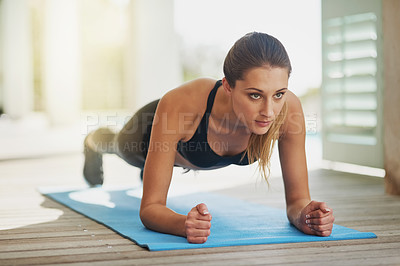Buy stock photo Shot of an attractive young woman planking on her patio