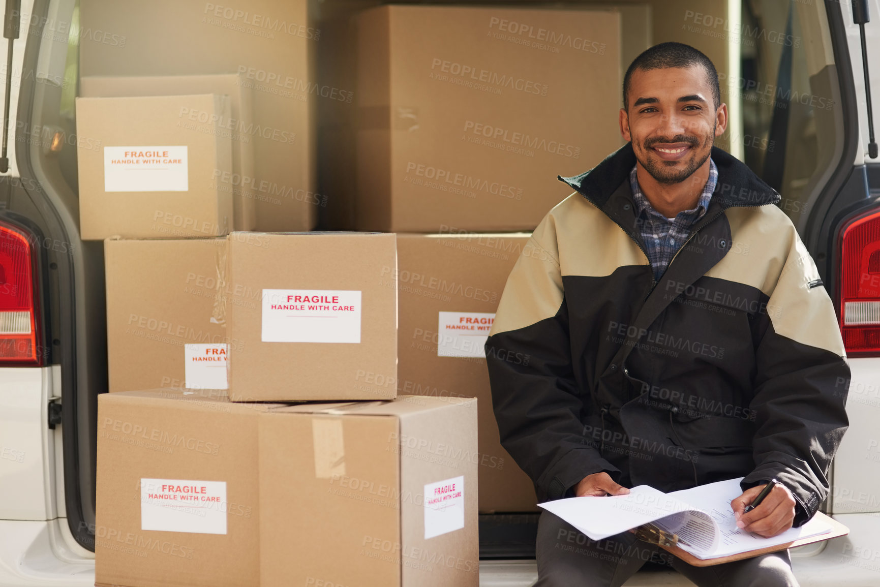 Buy stock photo Portrait of a delivery man sitting in the back of his van full of boxes